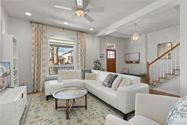 living room featuring baseboards, stairway, and wood finished floors