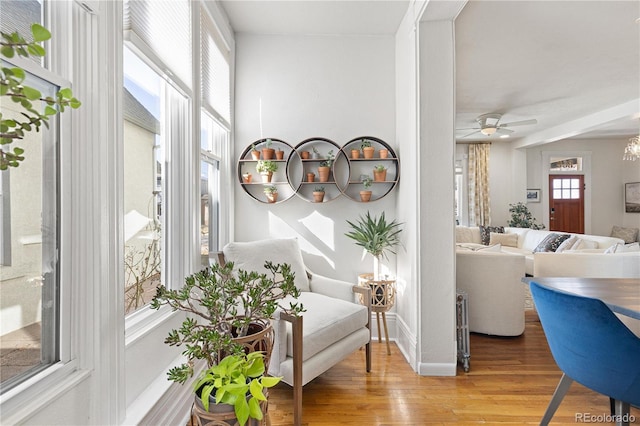 interior space featuring a ceiling fan, light wood-style flooring, and baseboards