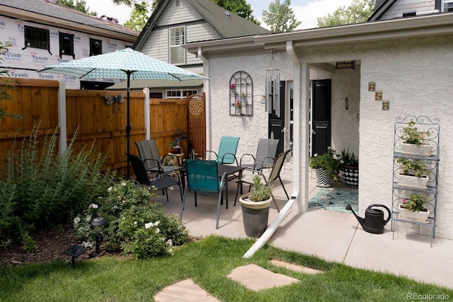 view of patio featuring outdoor dining space and fence