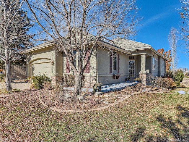 view of front of house featuring stone siding, an attached garage, and stucco siding