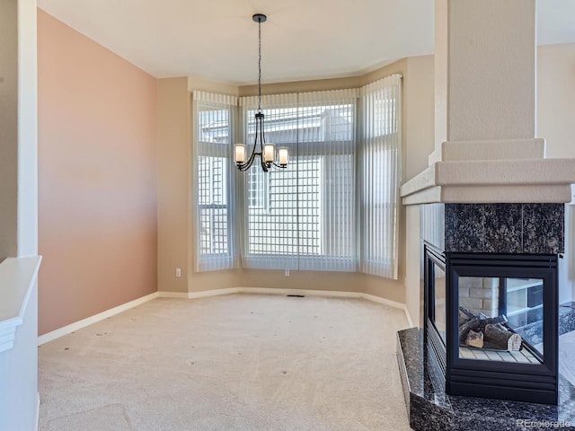 dining room featuring a multi sided fireplace, carpet flooring, and an inviting chandelier