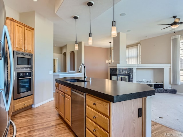 kitchen featuring plenty of natural light, an island with sink, stainless steel appliances, and light hardwood / wood-style floors