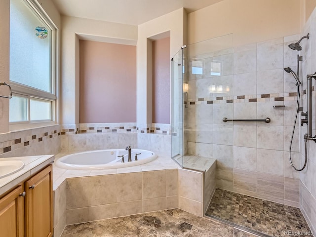 bathroom with vanity and shower with separate bathtub