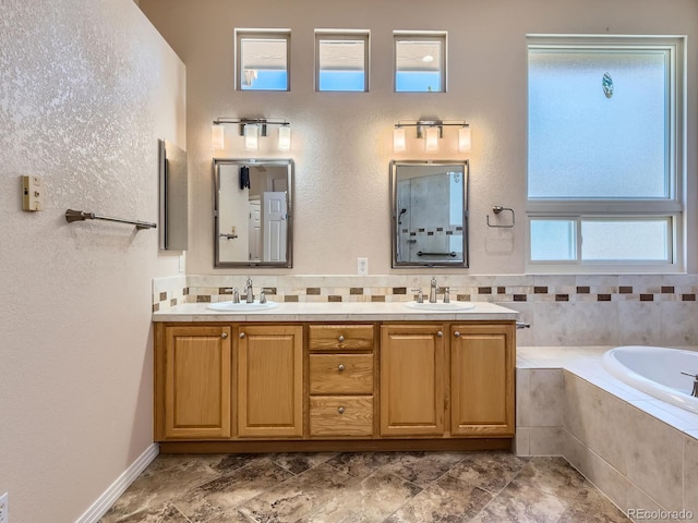 bathroom featuring vanity and tiled bath