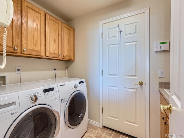 washroom with washing machine and clothes dryer and cabinets