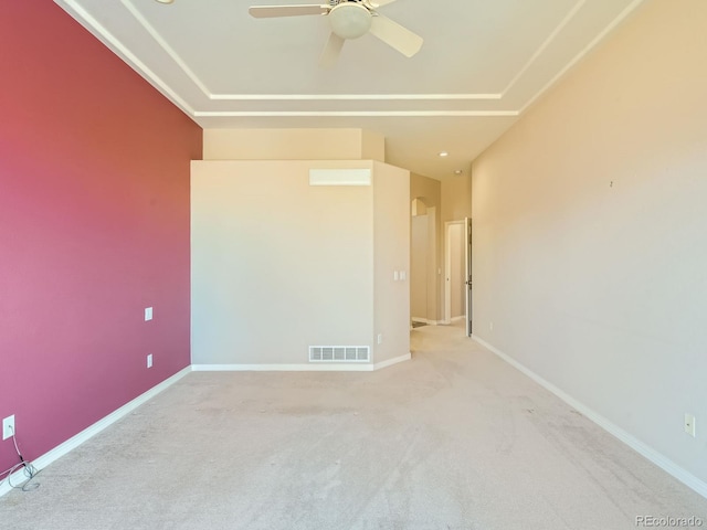 carpeted spare room with a ceiling fan, visible vents, and baseboards