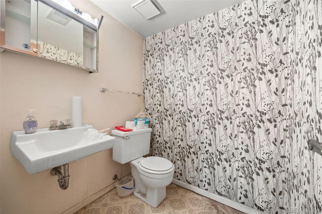 bathroom with a sink, a shower with curtain, toilet, and tile patterned floors