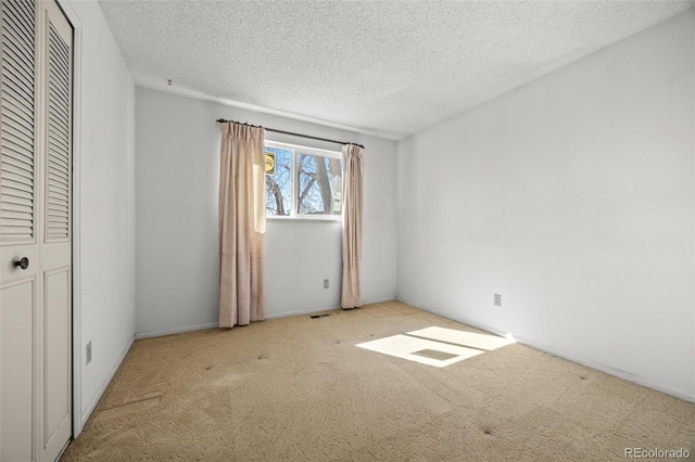 unfurnished bedroom with visible vents, carpet floors, and a textured ceiling