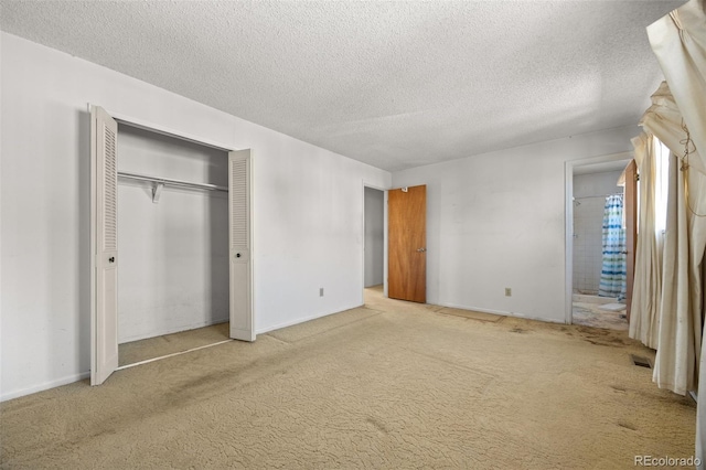 unfurnished bedroom with a closet, visible vents, a textured ceiling, and carpet floors