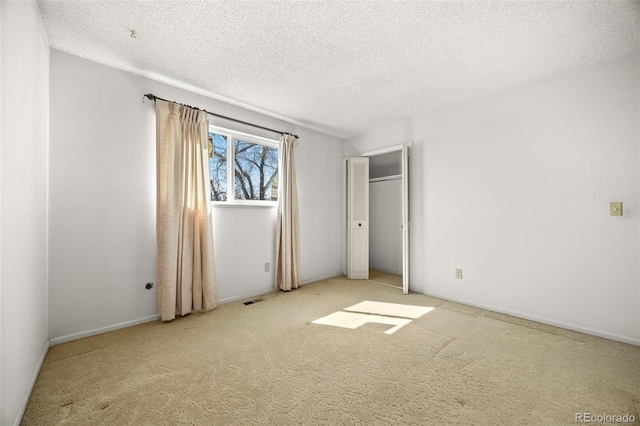 unfurnished bedroom with carpet flooring, visible vents, and a textured ceiling