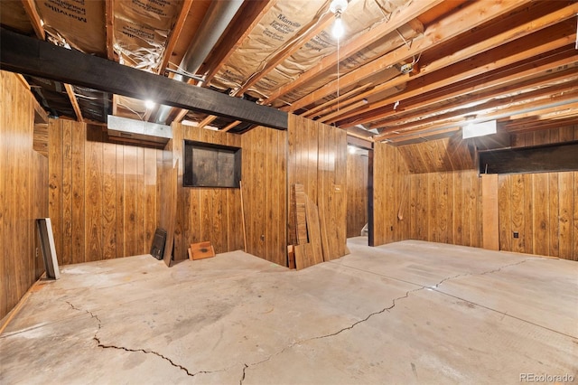 unfinished basement featuring wood walls