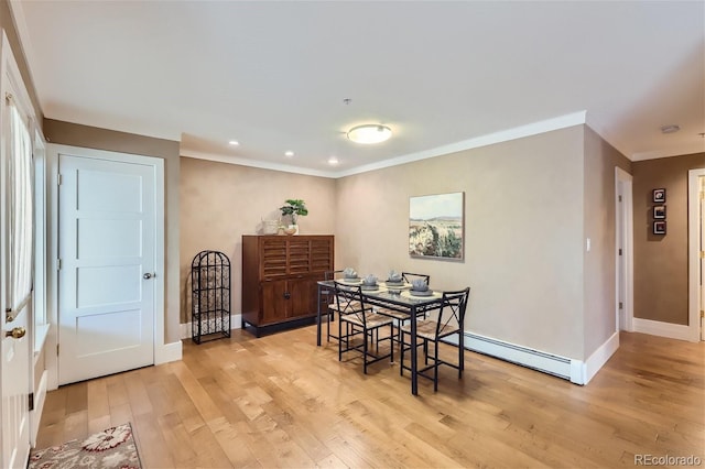 dining room with baseboards, a baseboard heating unit, ornamental molding, and light wood-style flooring