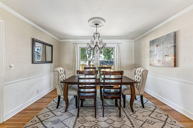 dining area featuring hardwood / wood-style floors, a notable chandelier, and ornamental molding