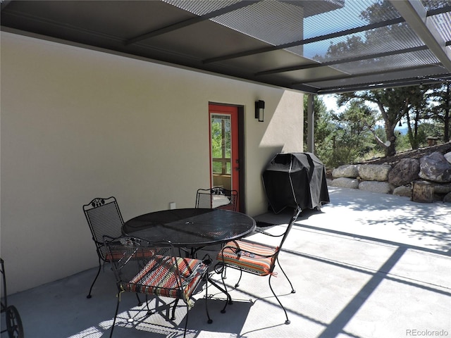 view of patio with area for grilling and a pergola