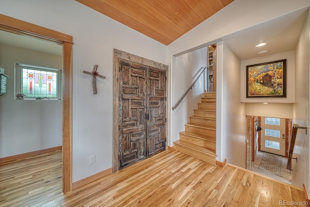 foyer featuring lofted ceiling, wooden ceiling, and light hardwood / wood-style flooring