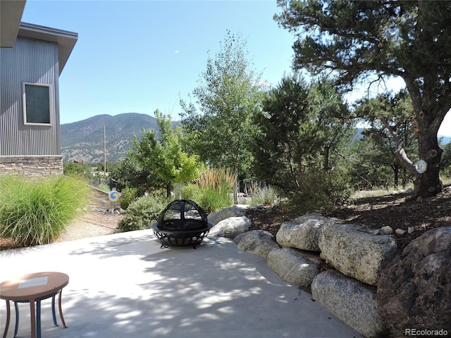 view of patio / terrace featuring a mountain view and a fire pit