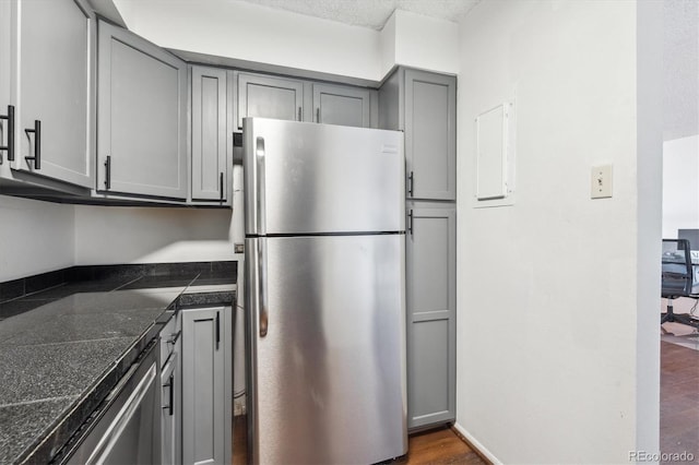 1020 15th St Unit 28G, Denver, CO 80202 - kitchen with stainless steel appliances, gray cabinets, tile countertops, dark wood-style flooring, and electric panel