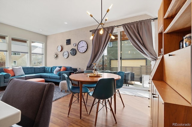 dining space featuring a notable chandelier and light wood-style flooring