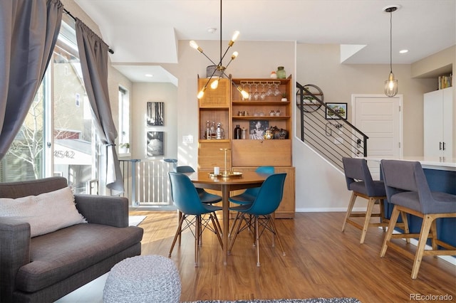 dining room with stairs, recessed lighting, baseboards, and wood finished floors