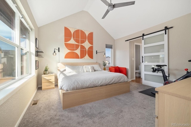 bedroom with a barn door, multiple windows, carpet, and visible vents