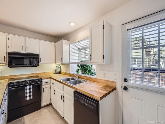 kitchen with sink, white cabinets, and black appliances