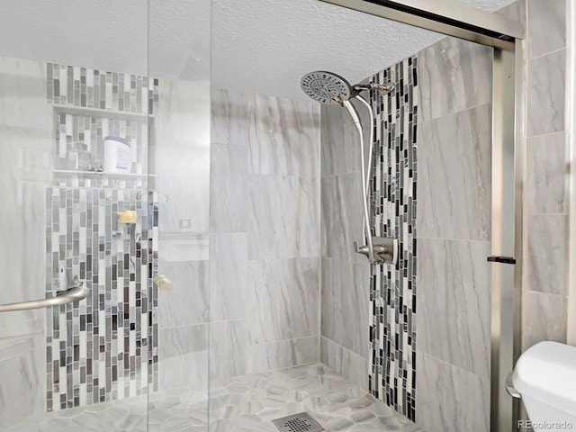 7318 S Xenia Cir Unit B, Centennial, CO 80112 - full bathroom featuring a stall shower and a textured ceiling