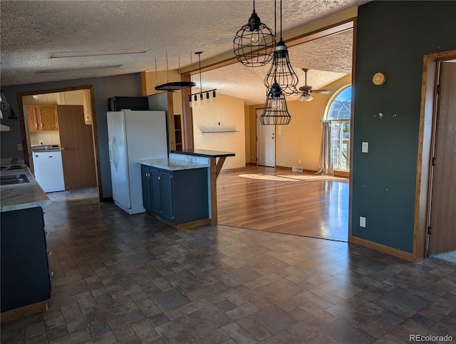 kitchen featuring a breakfast bar, pendant lighting, lofted ceiling, white refrigerator with ice dispenser, and a textured ceiling