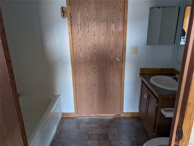 bathroom with vanity, stacked washer / drying machine, and a bathing tub