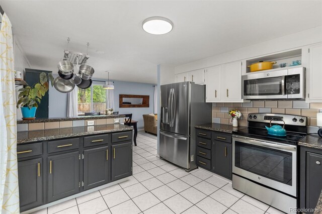 32 Powder Horn Pl, Longmont, CO 80504 - kitchen featuring appliances with stainless steel finishes, white cabinets, open shelves, backsplash, and light tile patterned floors