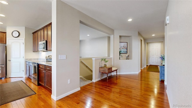 17114 Elati St, Broomfield, CO 80023 - kitchen featuring appliances with stainless steel finishes, light wood-style floors, recessed lighting, and light stone countertops
