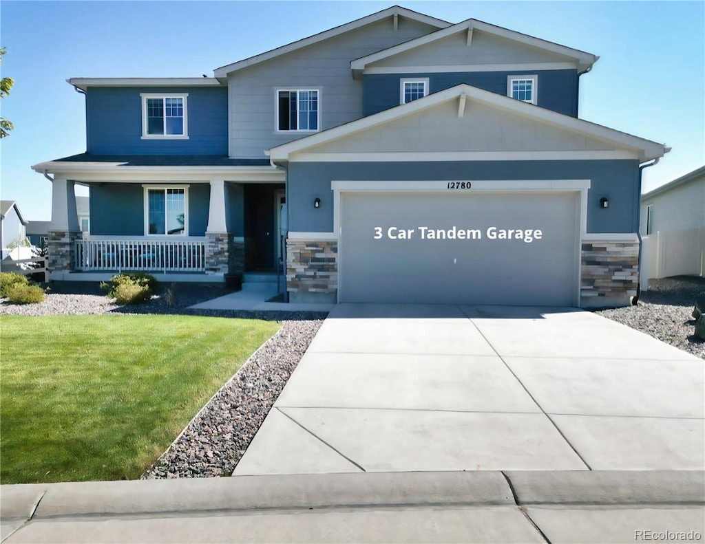 view of front of home with a garage, a porch, and a front yard