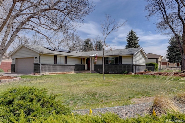 ranch-style house featuring brick siding, an attached garage, roof mounted solar panels, and a front yard
