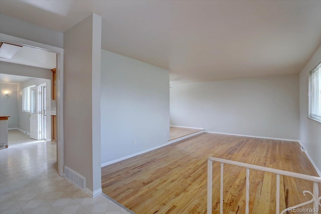 unfurnished room with baseboards, visible vents, and a healthy amount of sunlight