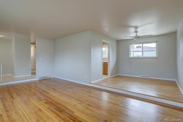 empty room featuring ceiling fan, visible vents, and light wood-style floors