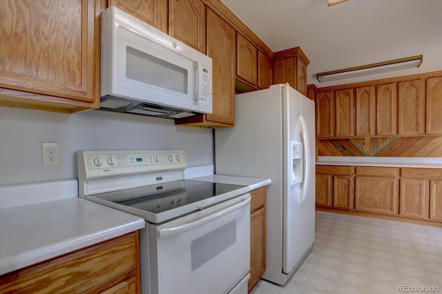 kitchen with white appliances, light countertops, brown cabinets, and light floors