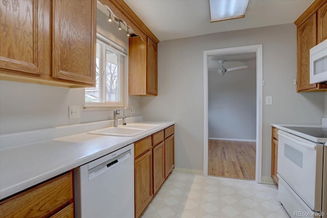 kitchen featuring a sink, white appliances, light countertops, a ceiling fan, and light floors