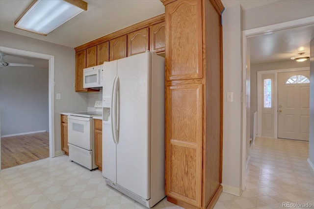 kitchen with white appliances, light countertops, baseboards, and light floors