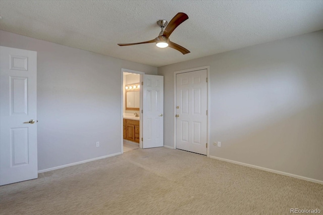 unfurnished bedroom with baseboards, a sink, connected bathroom, and light carpet
