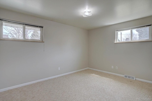 empty room featuring baseboards, carpet, and visible vents