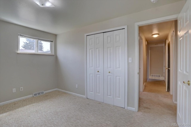 unfurnished bedroom with carpet floors, baseboards, visible vents, and a closet