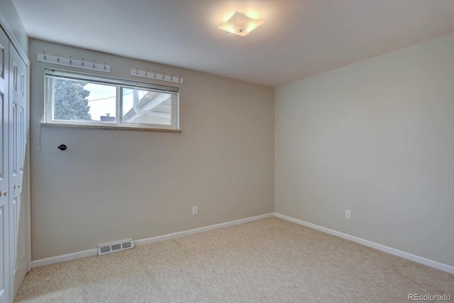 empty room with visible vents, carpet, and baseboards