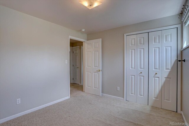 unfurnished bedroom featuring a closet, baseboards, and carpet flooring