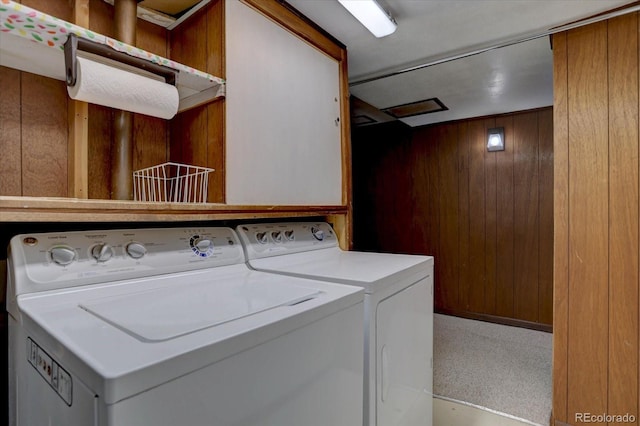 laundry area featuring wooden walls, laundry area, and washer and clothes dryer