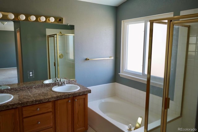 full bathroom featuring a bath, a shower stall, double vanity, and a sink