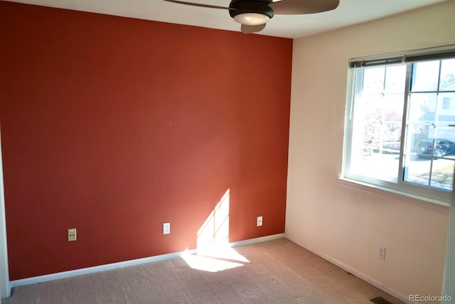 empty room featuring light carpet, plenty of natural light, and baseboards