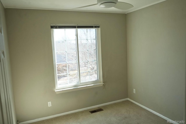 unfurnished room featuring carpet, crown molding, visible vents, ceiling fan, and baseboards