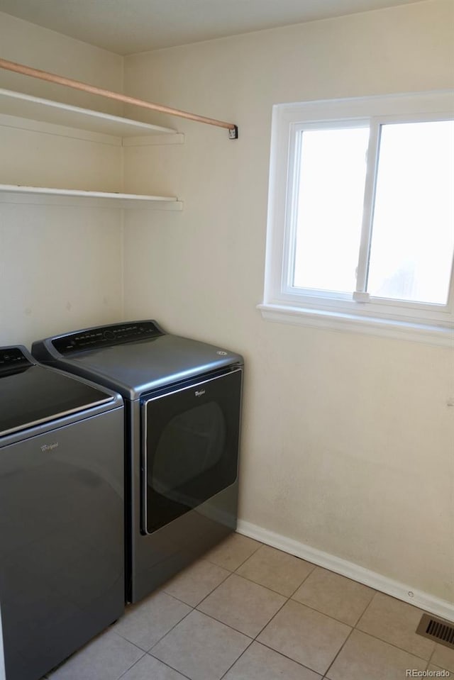 laundry area featuring laundry area, light tile patterned floors, baseboards, visible vents, and washer and dryer