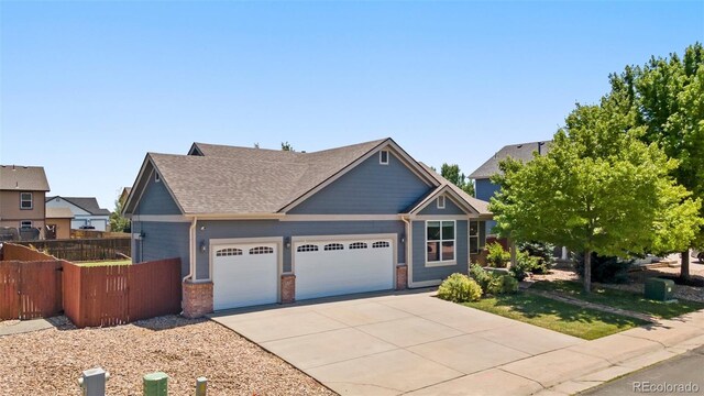 1884 Asoka St, Strasburg, CO 80136 - craftsman house featuring an attached garage, driveway, brick siding, and roof with shingles