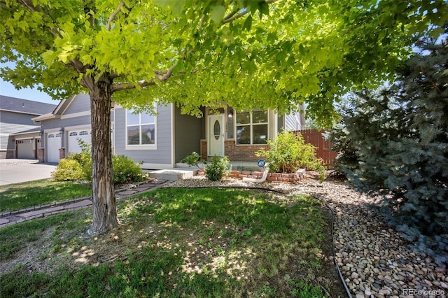 1884 Asoka St, Strasburg, CO 80136 - obstructed view of property featuring an attached garage, brick siding, and driveway