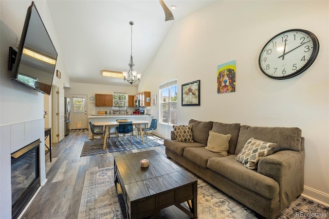 1884 Asoka St, Strasburg, CO 80136 - living area with a chandelier, high vaulted ceiling, wood finished floors, and a fireplace